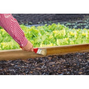 Auftragen des Lugato Schneckenschutz-Anstrich Schnexagon® auf eine Beetumrandung.
