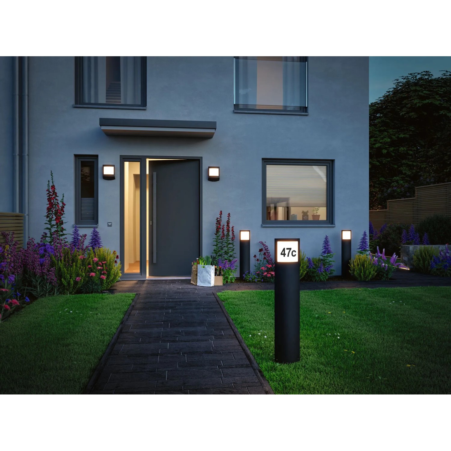 Paulmann LED-Outdoor-Wandleuchte Padea mit Sensor in Anthrazit an Hauswand mit Wegbeleuchtung.