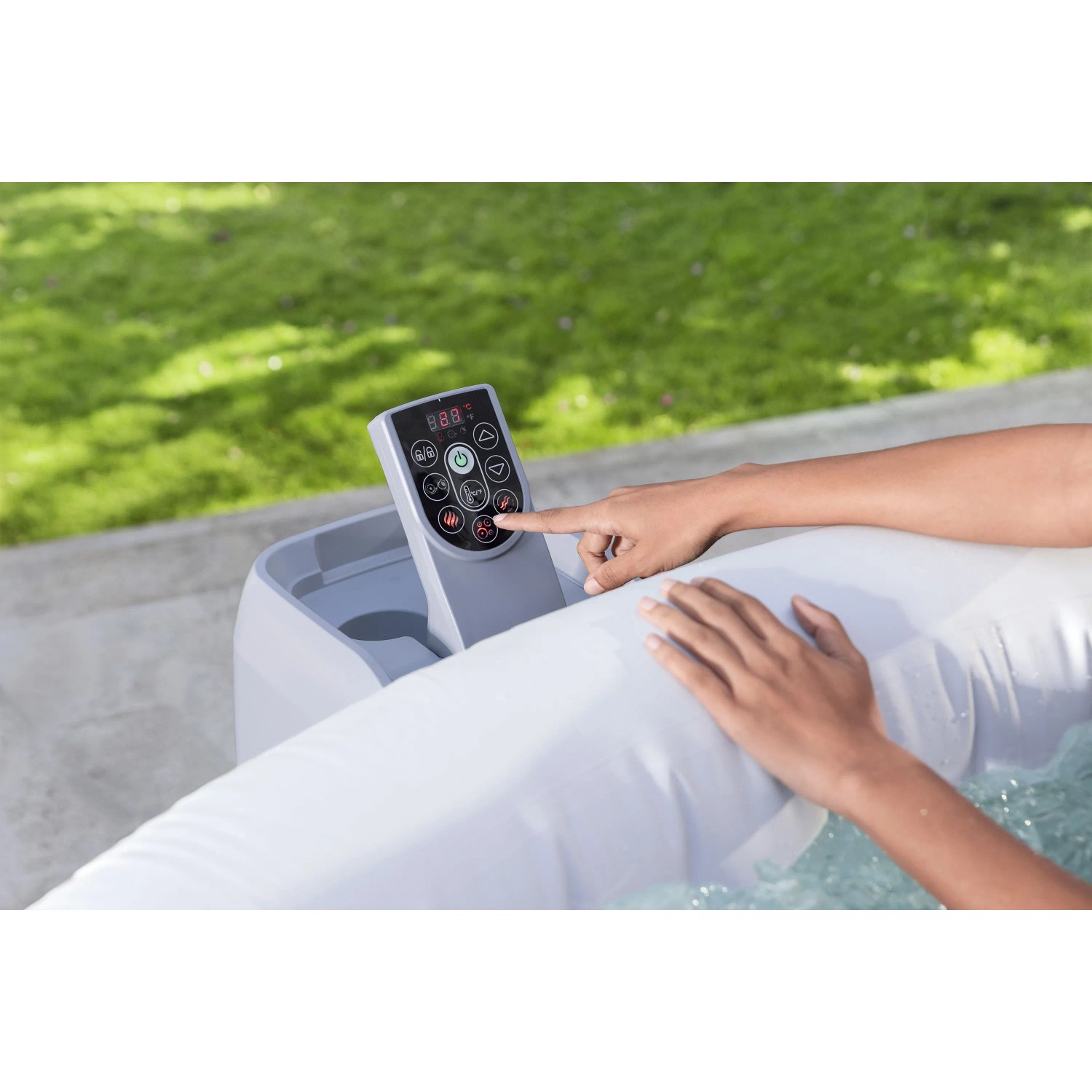 Hand bedient das Bedienfeld des Bestway Whirlpools Miami AirJet im Garten. Steuerung für aufblasbaren Whirlpool.