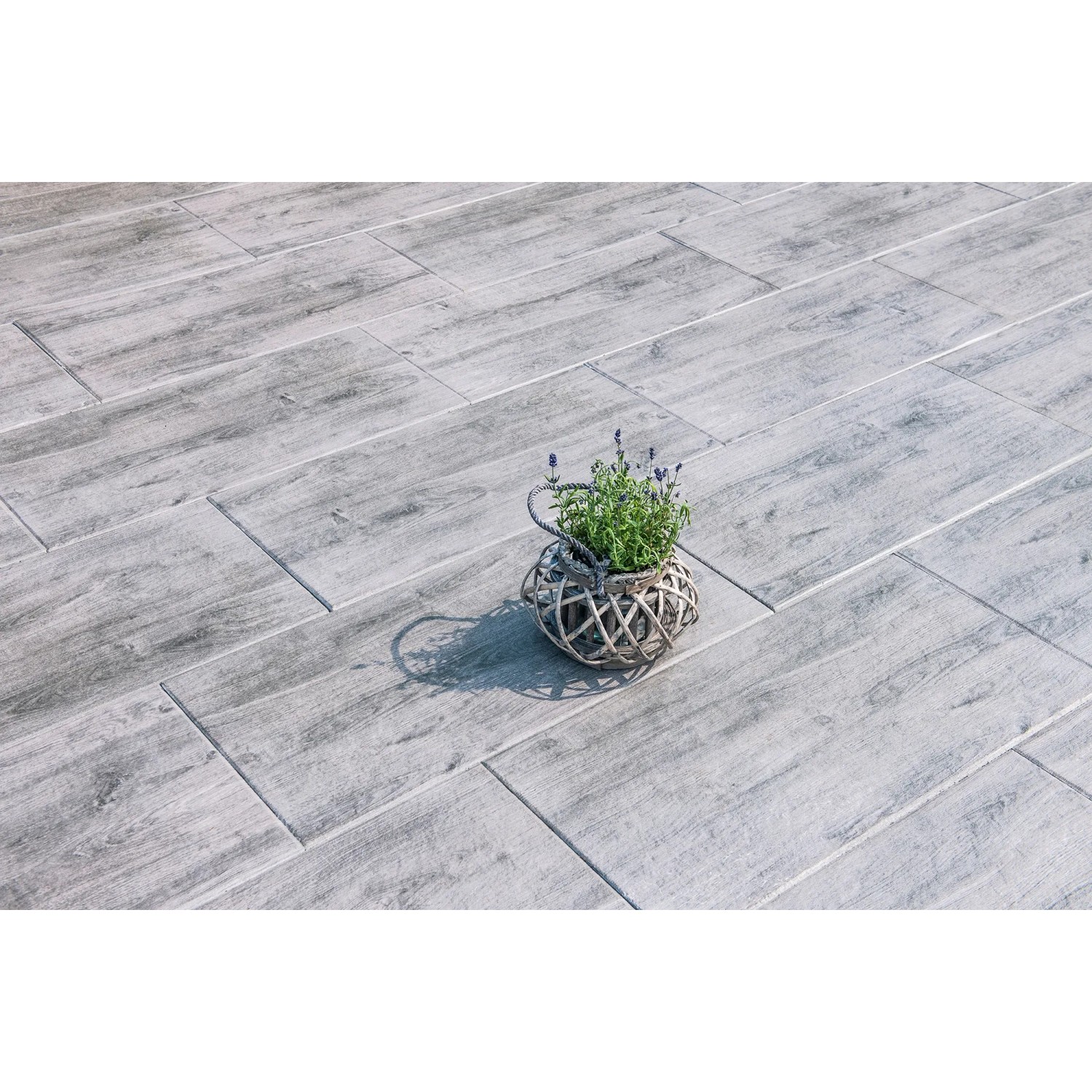 Diephaus Terrassenplatten Naturan, mittelgrau, mit Holzoptik und Pflanze im Korb.