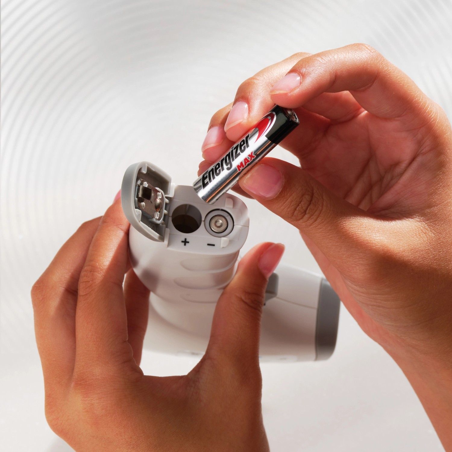 Einsetzen einer Energizer Max Micro AAA Batterie in ein elektronisches Gerät.