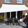 Cremeweißes Floracord Vierecksonnensegel HDPE 360x360 cm über einer Terrasse mit Tisch und Stühlen.