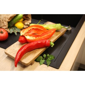 Rote Blu Bio-Spitzpaprika Conored (Capsicum annuum) auf Holzbrett mit Gemüse.