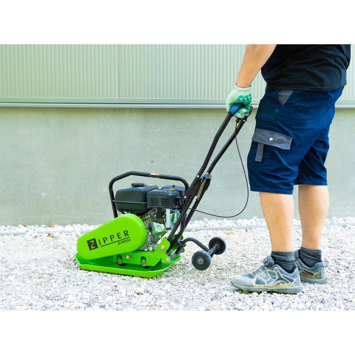 Zipper Rüttelplatte ZI-RPE60 mit Gummiplatte und Fahrwerk im Einsatz zur Bodenverdichtung.