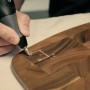 Dremel 290-3 Gravierer beim Gravieren eines Holzbretts mit dem Buchstaben E.