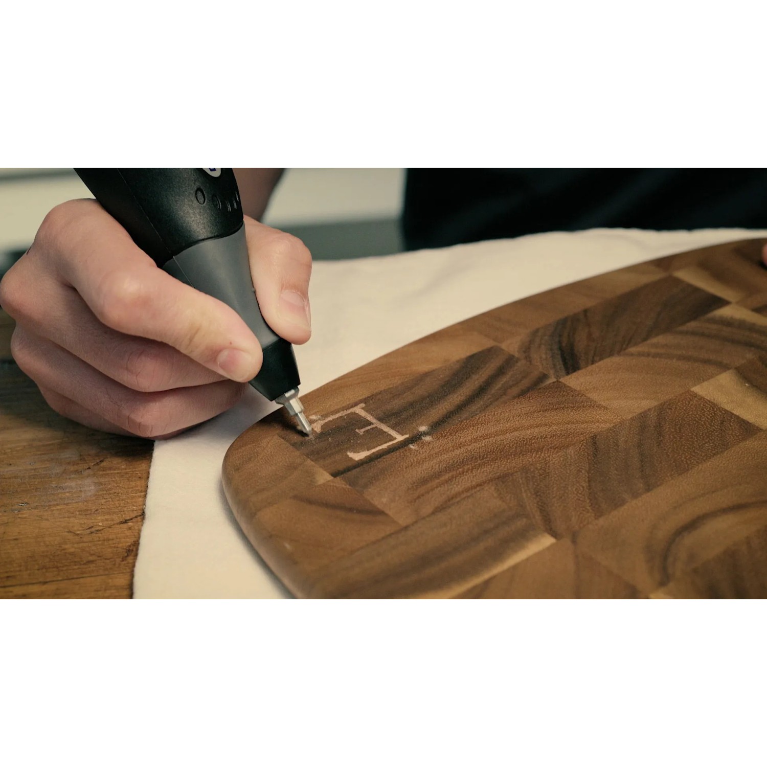 Dremel 290-3 Gravierer beim Gravieren eines Holzbretts mit dem Buchstaben E.