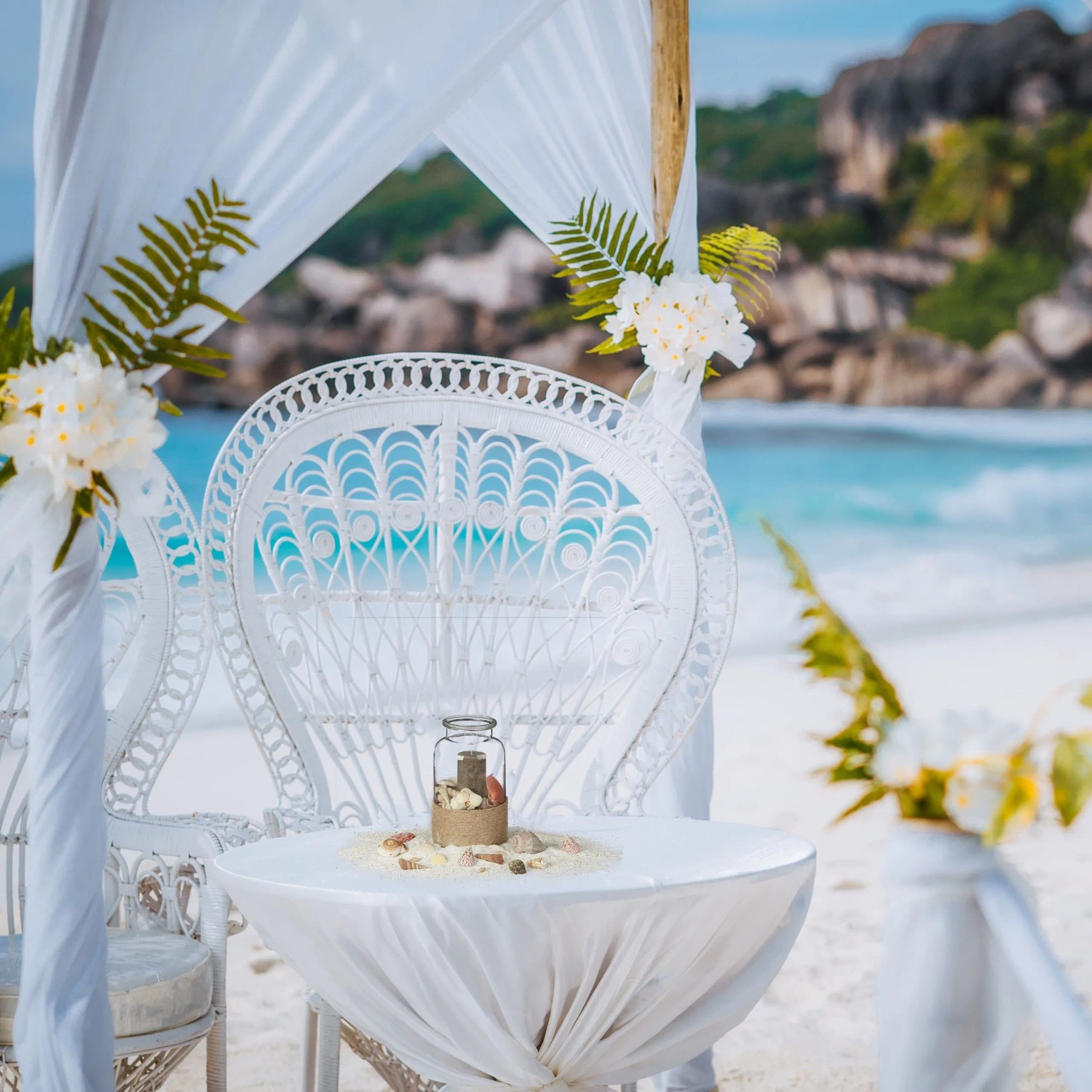 Dekoratives Muschel Set Natur Bunt in Glasgefäß auf weißem Tisch am Strand, ideal für maritime Deko.