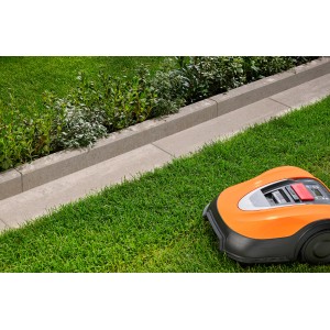 Randstein Vero Sienna-Nuanciert (100x25x6 cm) im Garten mit Rasenmähroboter.