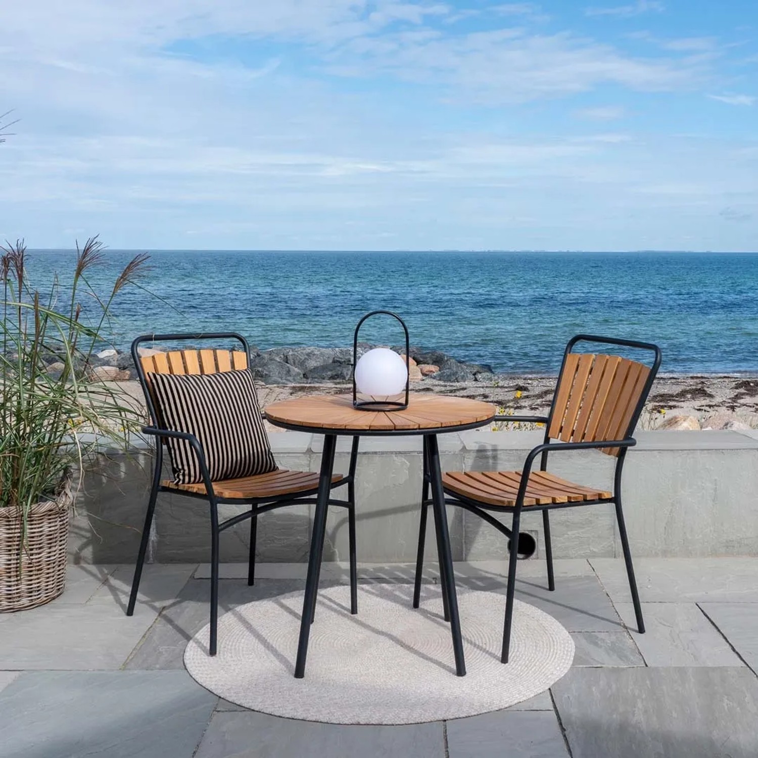 ebuy24 Cleveland Cafétisch (Ø70cm) aus Teakholz mit zwei Stühlen im Garten.