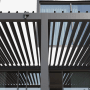 Anthrazitfarbene Pergola mit verstellbaren Lamellen für flexiblen Sonnenschutz. Modernes Design für Garten & Terrasse.