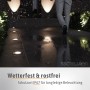 Schwarze SSC-LUXon Juavi Bodeneinbauleuchten mit warmweißem Licht beleuchten einen regnerischen Weg.