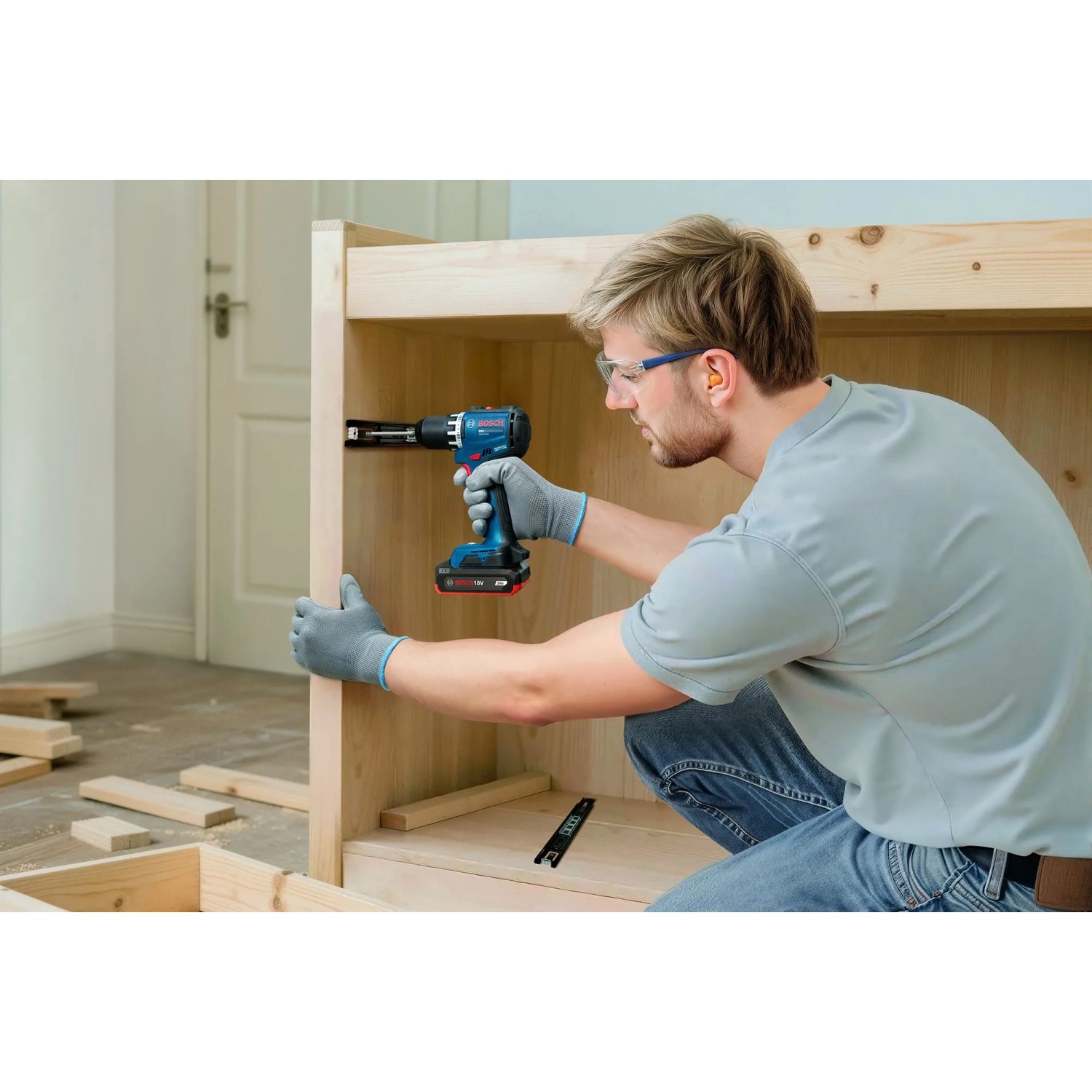 Mann bohrt mit blauem Bosch Professional Akku-Bohrschrauber in Holzregal. Kompaktes Akkugerät für präzises Schrauben & Bohren.