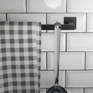 Schwarze ML-Design Kleiderstange Übereck aus Stahl an weißer Wand mit Geschirrtuch und Schöpfkelle.