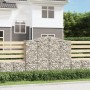 Zwei Gabionen mit Hochbogen als dekorative Gartenmauer, gefüllt mit Steinen.