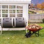 Lifetime Trommelkomposter 380 l mit Schubkarre voller Laub im Garten.