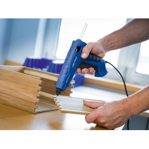 Anwendung einer blauen LUX Heißklebepistole mit transparenten Heißklebepatronen zum Verkleben von Holz.