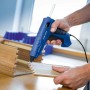 Anwendung einer blauen LUX Heißklebepistole mit transparenten Heißklebepatronen zum Verkleben von Holz.