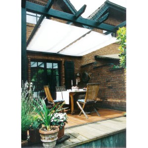 Weißes Peddy Shield Sonnensegel (275x96 cm) über einer Terrasse mit Tisch und Stühlen.