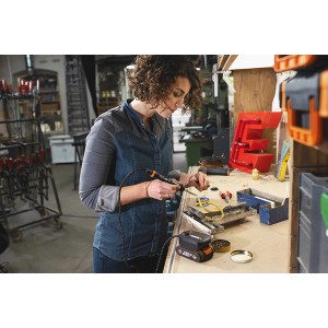 Frau lötet mit Worx MakerX 20 V Akku-Lötkolben WX744.9 an Werkbank. Lötgeräte für präzises Arbeiten.