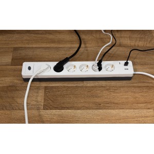 Weiße REV Ritter Steckdosenleiste Combini mit 6-fach Schuko, USB-Anschlüssen und angeschlossenen Kabeln.
