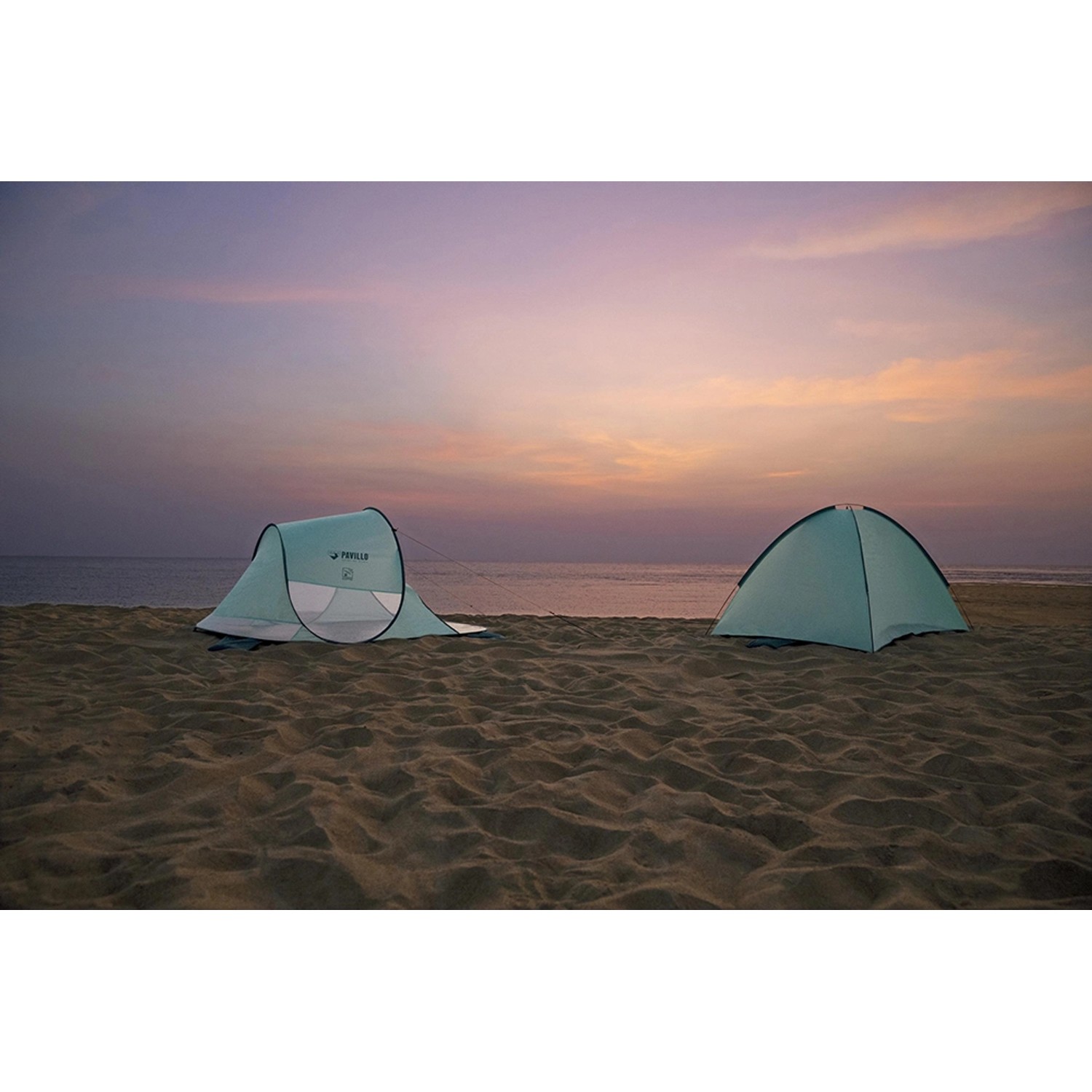 Zwei Pavillo Strandmuscheln Beach Quick 2 Tent am Strand bei Sonnenuntergang.