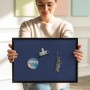 Frau präsentiert marineblaue Magnettafel mit schwarzem Rahmen, bestückt mit Reisemagneten. Praktische Magnetpinnwand für Notizen.
