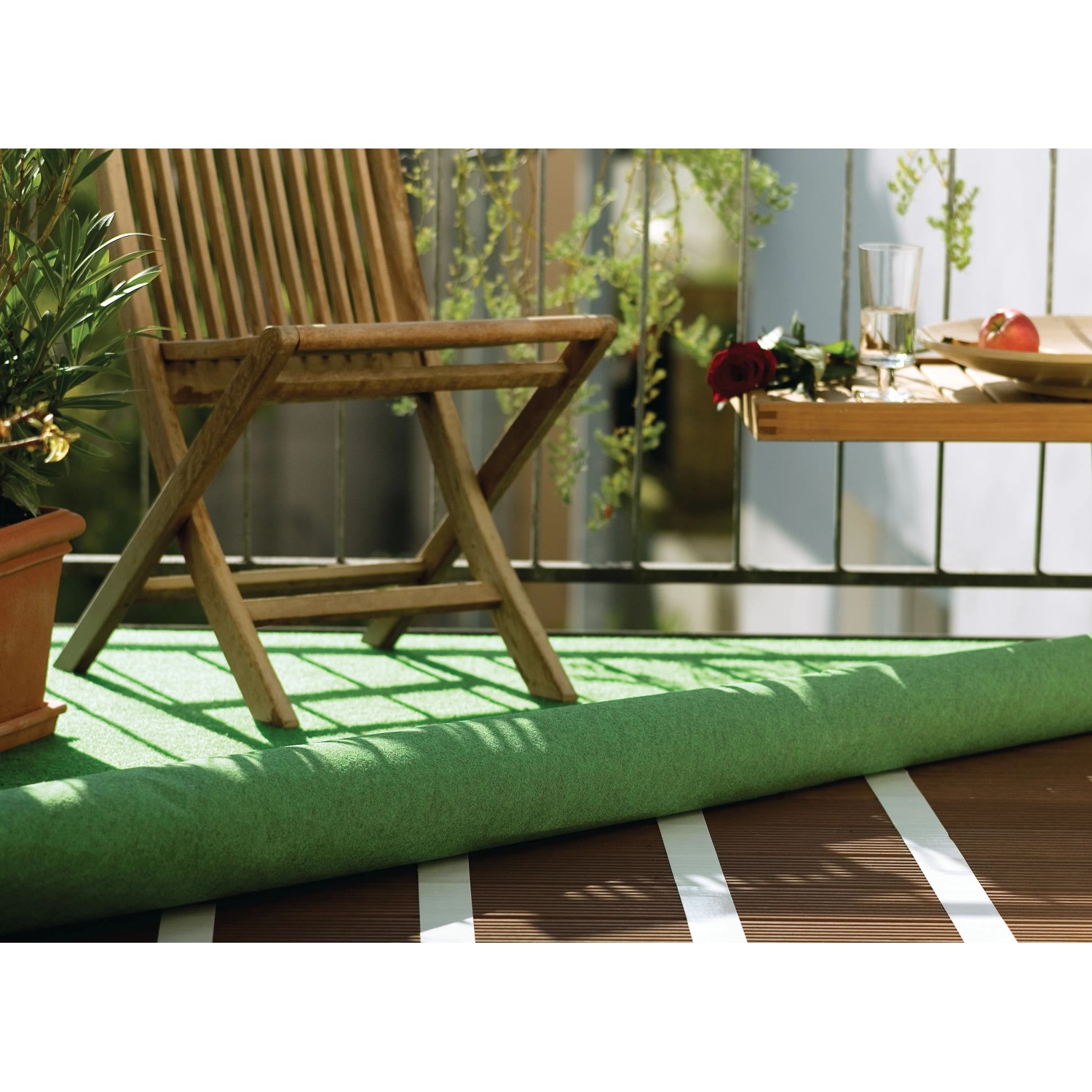 Tesa Verlegeband fixiert Kunstrasen auf Balkon mit Holzfliesen. Extra stark klebend für Teppich und PVC.
