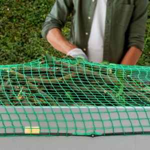 Grünes Anhängernetz aus Kunststoff (2x3m) mit Spannseil sichert Äste auf Anhänger. Für sicheren Transport von Ladungsgut.