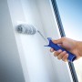 LUX Dispersionsroller 12cm in Nutzung: Farbroller mit blauem Griff streicht weiße Wand.