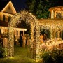 Warmweiße Salcar Solar Eiszapfen-Lichterkette dekoriert einen Gartenbogen und eine Pergola bei Nacht.