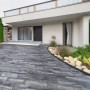 Verlegte EHL Artano Terrassenplatten in Grau-Anthrazit vor modernem Haus. Gehwegplatten mit R15 Rutschhemmung.