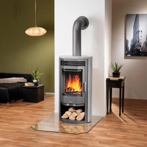 Justus Kaminofen Usedom 7 mit Specksteinverkleidung und Holzfach im Wohnraum.
