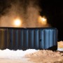 MSpa Tekapo AirJet aufblasbarer Whirlpool mit Hydromassage im Schnee bei Nacht.