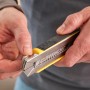 Stanley Cuttermesser FatMax 18mm, schwarz-gelb, mit Klingenmagazin in der Hand.