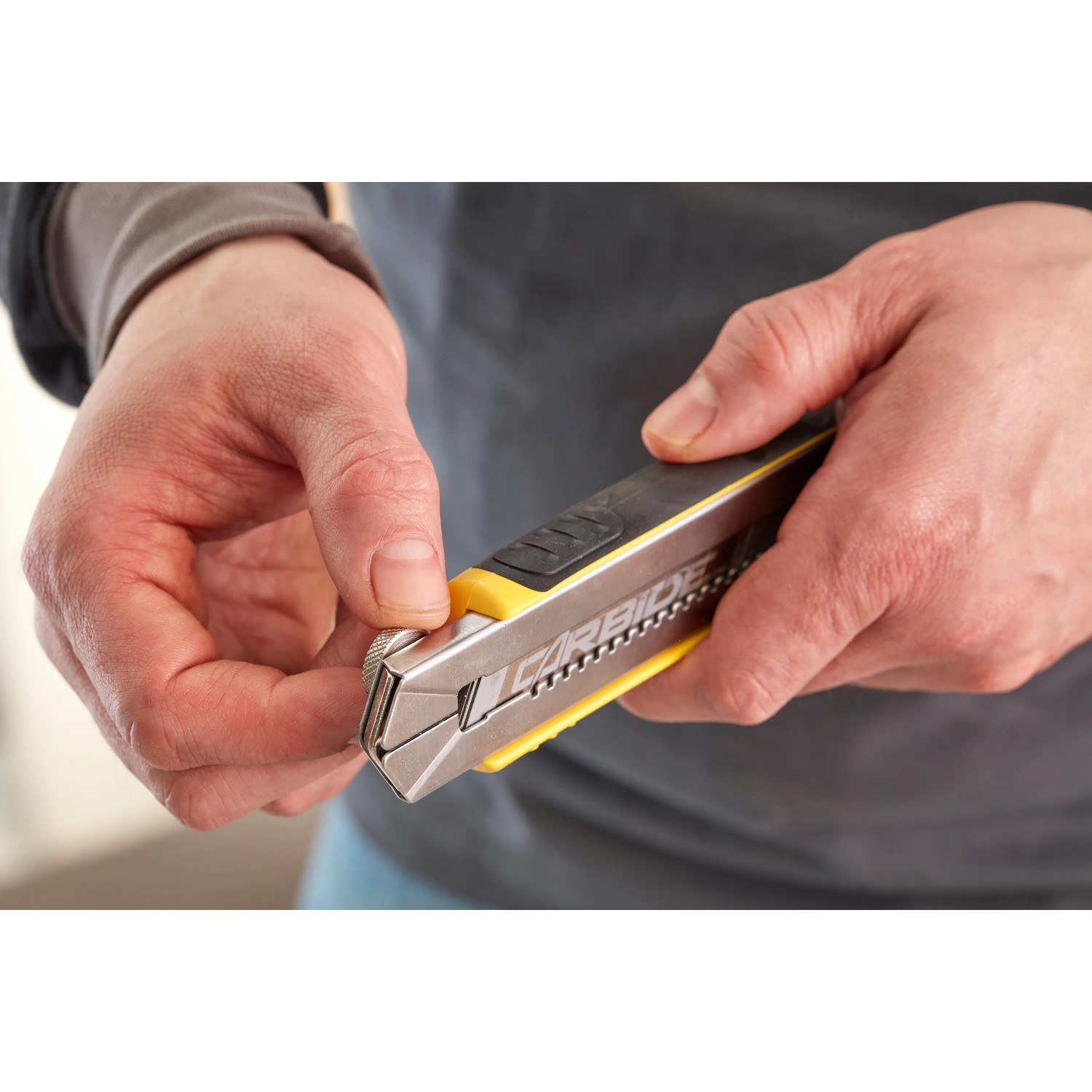 Stanley Cuttermesser FatMax 18mm, schwarz-gelb, mit Klingenmagazin in der Hand.