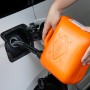 Orangefarbener OBI Benzinkanister (5 l) beim Befüllen eines Autotanks.