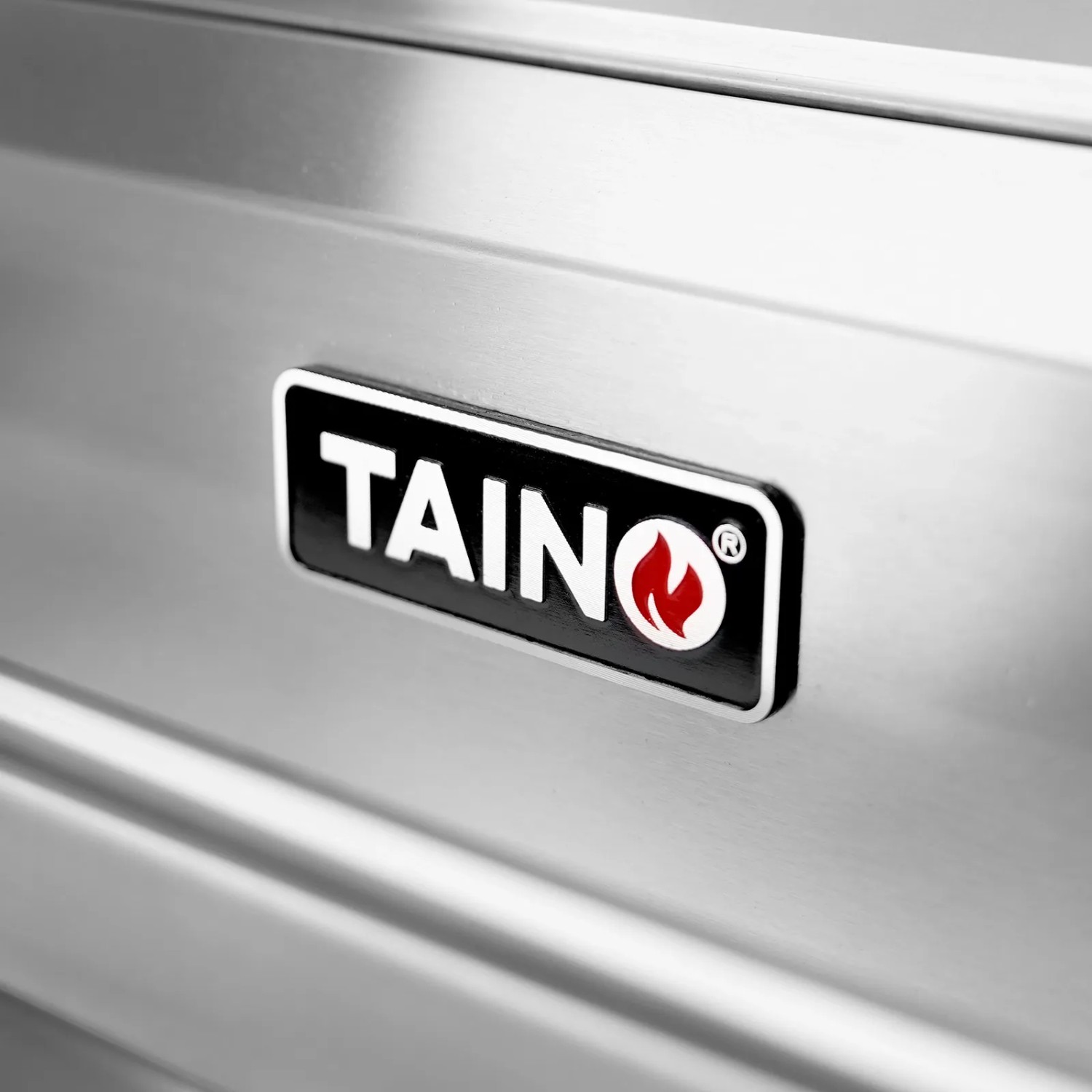 Detailaufnahme: Taino Platinum Gasgrill, Edelstahl, mit Taino Logo.