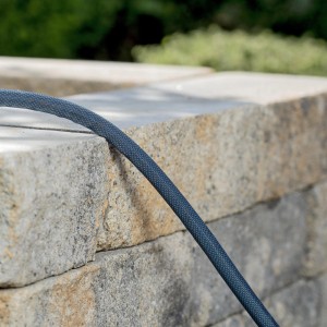 Gardena Liano Xtreme Textilschlauch 15m auf Steinmauer. Gartenschlauch-Set für Bewässerung.