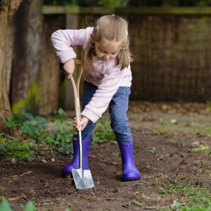 Mädchen benutzt Kent & Stowe Kinder-Spaten (71 cm) zum Umgraben im Garten.