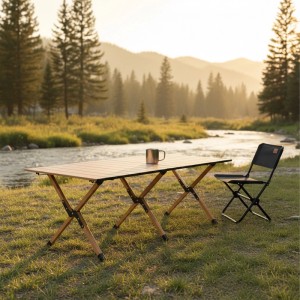 Klappbarer Campingtisch in Holzoptik am Flussufer. Wetterfester Falttisch aus Stahl für Camping & Outdoor, mit Stuhl.