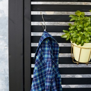 Schwarzer Sichtschutzzaun Tokyo aus Nadelholz mit Hemd und Pflanze als Dekoration.