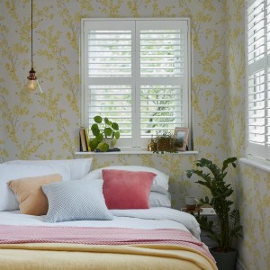 Schlafzimmer mit Laura Ashley Vliestapete Forsythia Sunshine mit gelbem Blütenmuster.