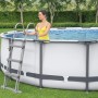 Bestway Stahlrahmenpool Steel Pro Max, Ø 366 cm, mit Leiter. Frau steigt in den Pool.