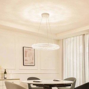 Dimmbare LED Smart Home Pendelleuchte Tumata transparent über Esstisch.