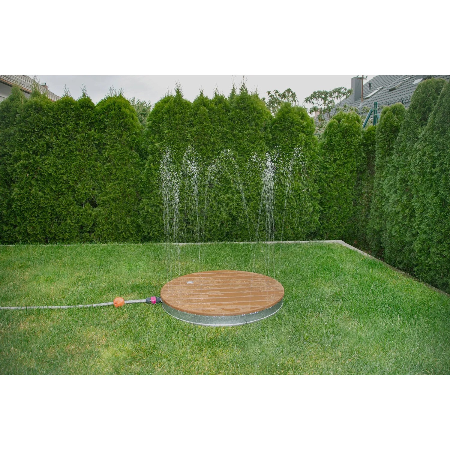 Summer Fun Gartendusche Shower UP mit runder Teak-Platte und Wasserfontäne im Garten.