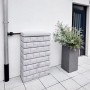 Garantia Wandtank Rocky Junior 300 l Light Granite in Steinoptik neben Fallrohr und Pflanzkübel.