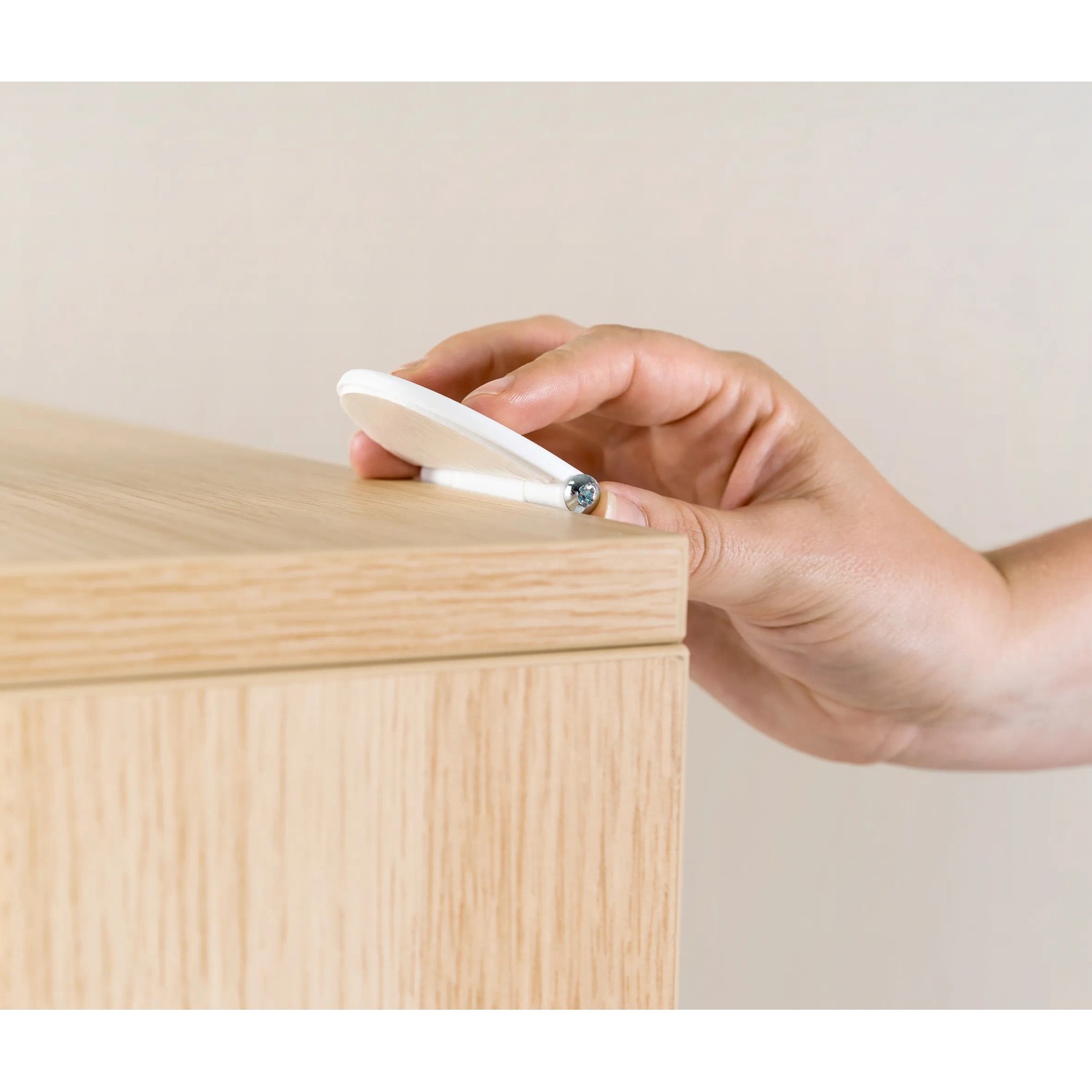 Reer Möbel-Kipp-Sicherung wird an einem Holzmöbelstück befestigt.