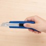 Hand hält blaues LUX Cuttermesser Classic 100 mm. Messer mit Metallgehäuse und Klingenarretierung.