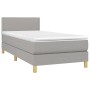 Helles, graues Boxspringbett 90x190 cm mit Matratze und Kopfteil.