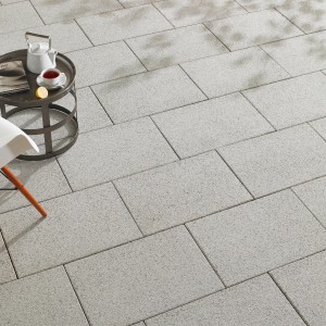 Verlegte, wassergestrahlte Terrassenplatten Mailand in Weiß-Schwarz, 60x40 cm, mit Tisch und Dekoration.
